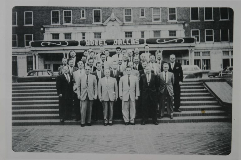 Group of people standing on steps in front of a building.