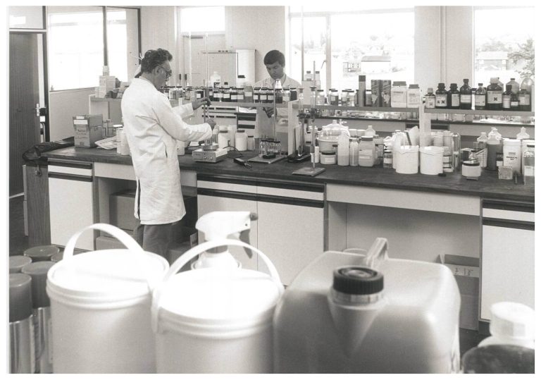 Chemical manufacturing laboratory with two chemists working on product formulations.