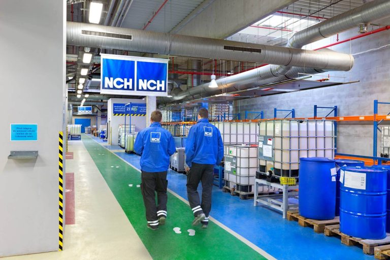 Two employees walking through the NCH manufacturing facility in Czech.