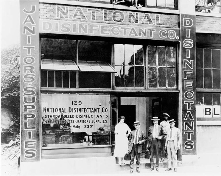 Old image of first ever NCH business with employees in the doorway.